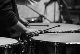 Fototapeta  - Hands of a musician playing the timpani in an orchestra close-up in black and white