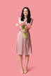 © Pixel-Shot - Happy young woman with bouquet of tulips on pink background. International Women's Day