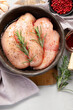 Raw marinated chicken meat with rosemary and sauce in a grey bowl. Marinating meat for cooking.
