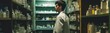 Man in a lab coat standing in front of a shelf of bottles. pharmacist background 