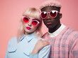 © Johannes - Young Gen Z fashion mixed couple with trendy pink sunglasses, heart in the background, love and Valentine's day concept, fun pastel colors, diversity hd