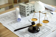 © Worawith - Wooden gavel, house and yellow helmet