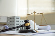 © Worawith - Wooden gavel, house and yellow helmet