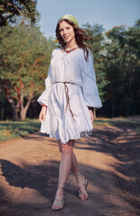 Outdoor fashion: beautiful young boho (hippie) girl in grove (forest). Portrait of lovely smiling hippy girl on the road