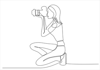 Wall Mural - A girl takes a photo with her camera. He is a photographer. He loves to capture every moment with his camera. One continuous line. Vector illustration