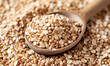 closeup whole grain buckwheat and oats in a rustic wooden spoon