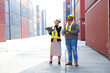 © krongthip - Engineer wearing safety helmet working at container warehouse.