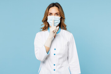 Wall Mural - Female secret doctor woman wears white medical gown suit mask gloves work in hospital clinic office do shh hush gesture, be quit isolated on plain blue background studio. Health care medicine concept.