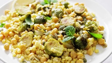 Sticker - Vegetarian Tabbouleh Salad. Couscous brussels sprouts and chickpeas warm salad with pumpkin seeds. Healthy vegetarian diet food. Stock footage video 4k