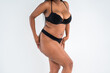 © staras - Curvy busty plus size model in push up bra on gray background, overweight African black woman in sexy lingerie, fat body with cellulite