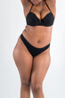 © staras - Curvy busty plus size model in push up bra on gray background, overweight African black woman in sexy lingerie, fat body with cellulite