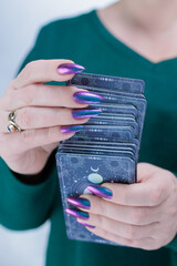 Female hands holding tarot cards for fortune telling and tricks