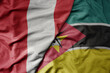big waving national colorful flag of mozambique and national flag of peru .