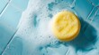 Top view photo of yellow soap lying on the bathroom floor with shampoo foam on blue tiles. Round soap in the bathroom full of foam in conceptual art.