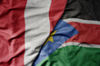 big waving national colorful flag of south sudan and national flag of peru .