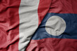 big waving national colorful flag of laos and national flag of peru .