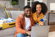 © Prostock-studio - african couple using laptop and credit card booking tour indoor