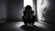 © Lee - Depressed woman sitting alone on the floor with head in hands, black and white