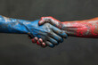 Handshake with hands painted in blue and red resembling political unity