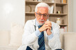 © Юлия Завалишина - Sad tired mature senior male doctor in medical uniform in hospital or doctor office. Unhappy General Practitioner GP therapist professional healthcare expert in clinic. Healthcare concept