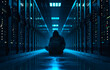Hooded computer hacker trying to load malware and  breach the cyber security of modern data center full of server racks