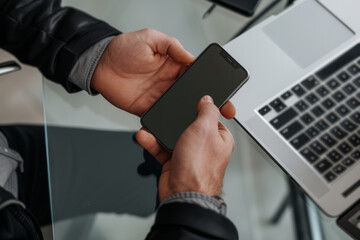 Poster - A person holding a cell phone in front of a laptop