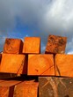 Fresh wood blocks impregnated for the construction and building industry.  Wood pieces on a blue cloudy sky background.