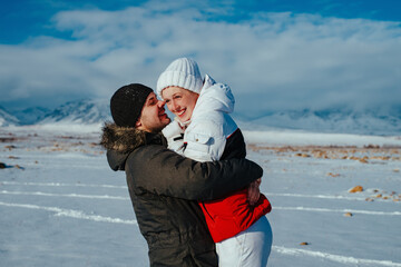 Sticker - Romantic young couple embracing on mountains background in winter