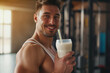 Fit young man in gym drinking protein cocktail. Athletic man in sportswear holding a shaker with healthy drink. Protein shake. exercising concept. Fitness and healthy lifestyle, sports nutrition