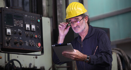 Wall Mural - worker or engineer working in factory with safety uniform , safety hat and safety glasses , image is safety concept or happy workplace