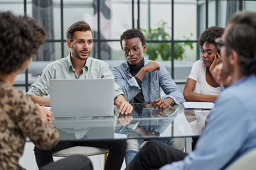 Employees working at computer together, discussing content