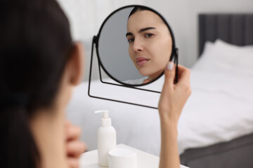 Canvas Print - Woman with dry skin looking at mirror indoors