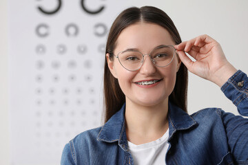 Sticker - Young woman with glasses against vision test chart