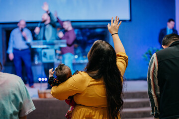 Lady and baby raising hands in praise, Worshiping