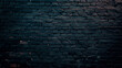A brick wall with a gradient of dark blue and black hues