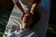 a therapist massage a woman who laying down on a massage bed