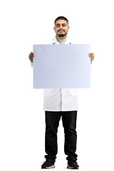 Canvas Print - The doctor, in full height, on a white background, shows a white sheet