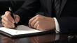 © Ali - business man holding a pen signing on paper, contract sign concept