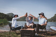 Group of travallers camping with friends they join drinking and playing guitar together with happiness activity camping near nature lake with mountain background is holiday summer camping concept