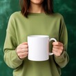 © crazyass - Girl in a green sweater holding a white mug