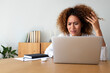 © Daniel - Multiracial hispanic woman feeling angry and frustrated while working with laptop at home office. Copy space.