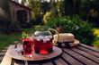 summer homemade cherry lemonade with ice in blooming garden with peonies. Summertime relax outdoor