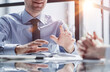 © Katsiaryna - Two business men sit at desk discuss project details sales manager makes commercial offer to company client
