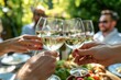 © Straxer - Group of people having a meal in the garden in summer and having a toast with white wine.