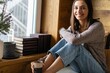 © opolja - Young woman drink tea coffee sit on sofa couch stay at home wooden wall