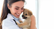 © Iryna - A veterinarian woman smiles while holding a cute puppy in her arms