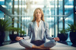 Female leader in suit doing yoga for relaxation at office. Businesswoman feels great learning Zen of calmness by concentrating on positive emotions at break