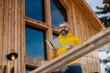© Halfpoint - Man standing on cabins patio, drinking hot tea, coffee and reading book. Handsome man spending relaxing, stress-free winter weekend in cabin in mountains, enjoying alone time.
