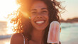 © Keitma - Portrait of a young smiling African American woman eating a popsicle ice cream on hot summer day at the beach