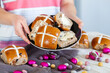 © Austockphoto - Buttered hot cross buns and scattered eggs at Easter on a plate